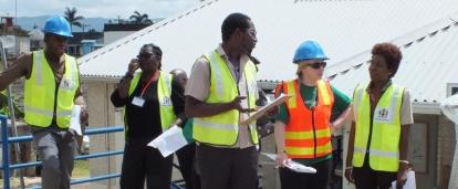 A group of Projects Abroad International Development Interns standing outside a building coordinating a plan during Disaster Management work experience in Jamaica. Disaster Management Interns developing plans outside during their International Development Placement in Jamaica.